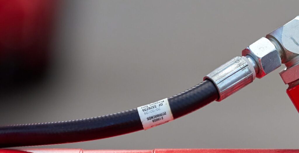 Close Up,of,two,hydraulic,hose,fittings,attached,to,a,red